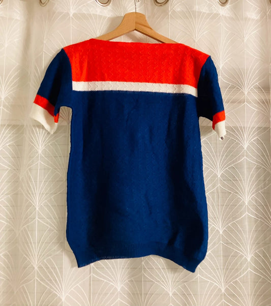 Pull tricoté bleu et rouge, style vintage, suspendu sur cintre