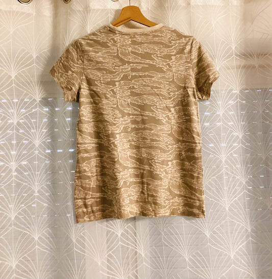 T-shirt beige à motif camouflage, suspendu sur cintre, vêtement seconde main tendance