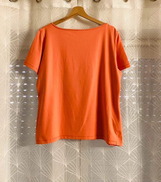 T-shirt orange à manches courtes suspendu sur cintre, vêtement d'occasion tendance