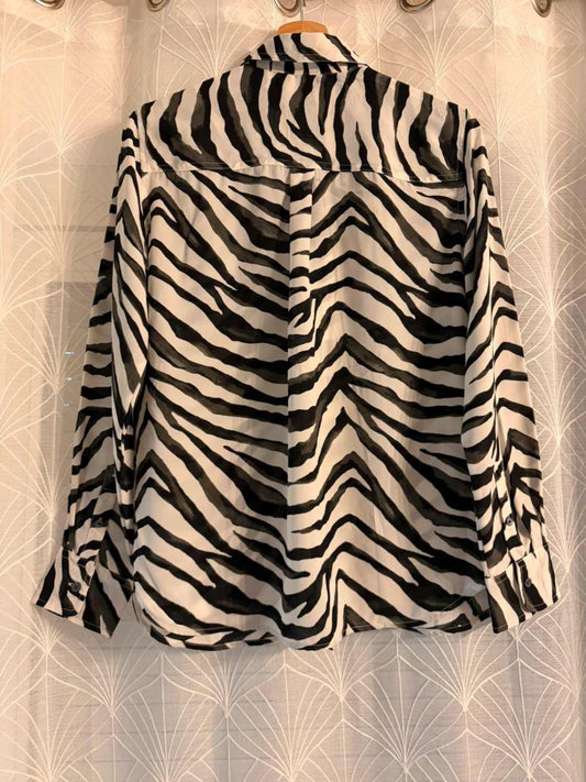 Chemise à motif zèbre noir et blanc, style mode seconde main, vue dos sur cintre