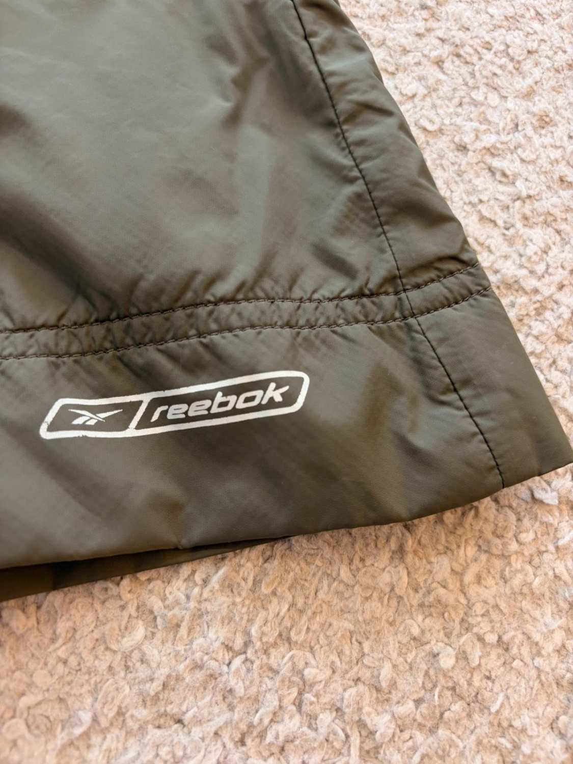 🤎 Veste Reebok Imperméable à Capuche Kaki - Protection & Style