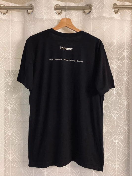 T-shirt noir Thrivent avec inscription blanche, suspendu à un cintre en bois
